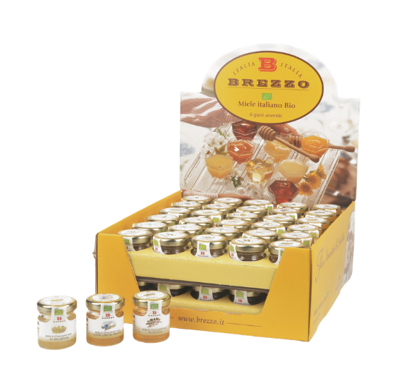 Display box of many small glass jars labeled Miele Italiano Bio, arranged in a yellow Brezzo stand for honey samples (Italian organic honey).